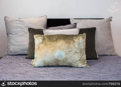 Bed maid-up with clean white pillows and bed sheets in beauty room. Close-up. Lens flair in sunlight. grey colors. Bed maid-up with clean white pillows and bed sheets in beauty room. Close-up. Lens flair in sunlight.