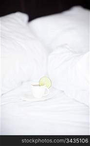 bed with a pillow and a cup of tea