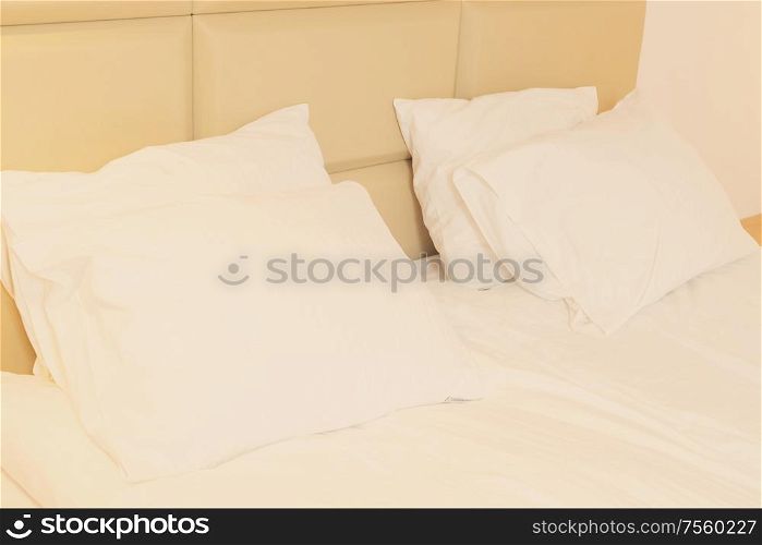 bed with white linen, pillows close up. bedroom interior closeup