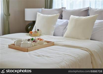 bedroom interior design with decorative tea set and dessert on bed