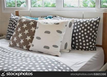 bedroom interior design with polka dot pillows on bed and decorative bedside table lamp.