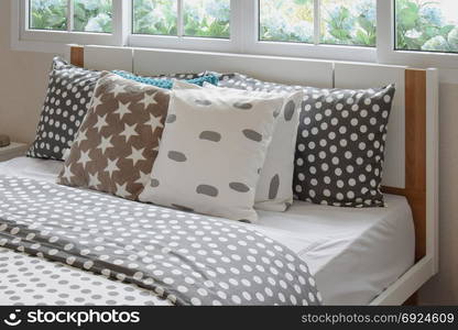 bedroom interior design with polka dot pillows on bed and decorative bedside table lamp.