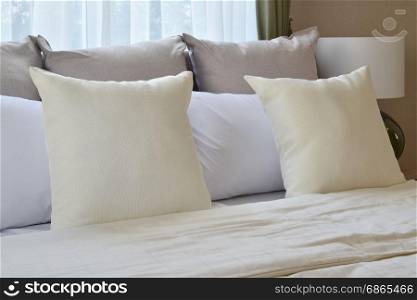 bedroom interior design with white pillows on bed and decorative table lamp.