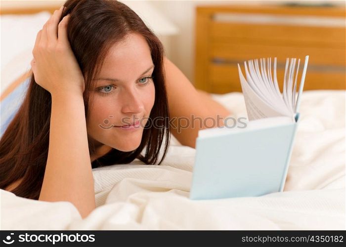 Bedroom - young woman read book in white bed