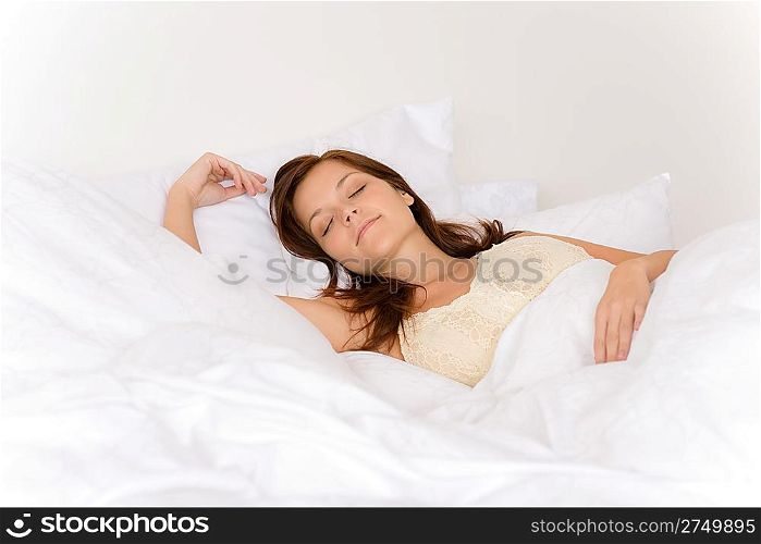 Bedroom - young woman sleeping and dreaming in white bed