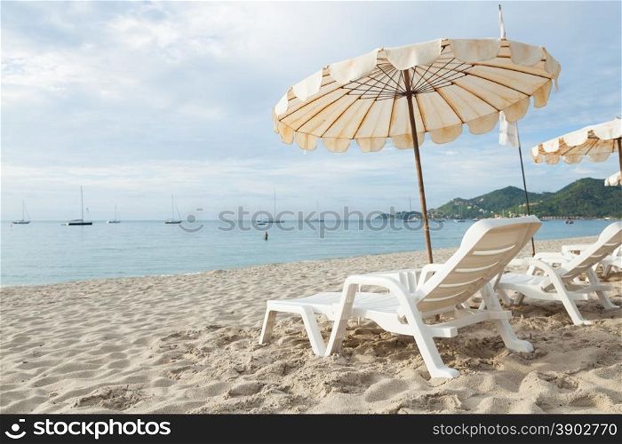 Beds and umbrellas on the beach. The seaside beach tourist attractions.