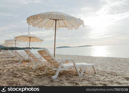 Beds and umbrellas on the beach. The seaside beach tourist attractions.