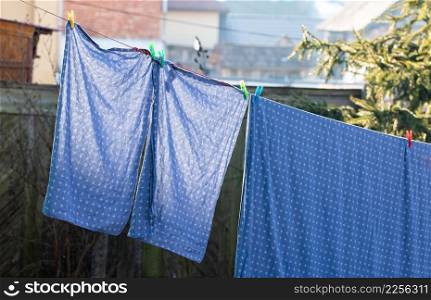 bedsheets hanging on clothesrack outdoors