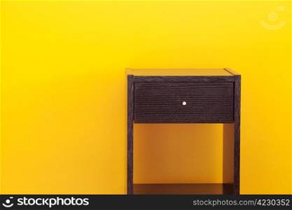 bedside table against a yellow wall in the apartment