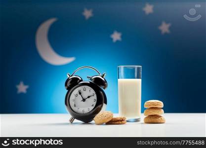 bedtime, sleeping and diet concept - close up of alarm clock, glass of milk and oatmeal cookies over moon and night stars on blue background. glass of milk, cookies and alarm clock at night