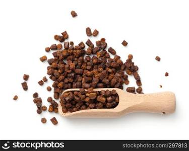 Bee pollen propolis in wooden scoop isolated on white background. Top view