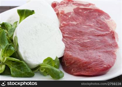 beef and mozzarella. photo of a raw beef with a fresh mozzarella
