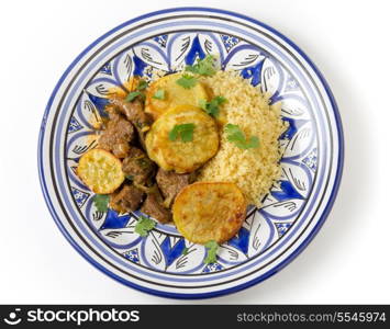 Beef and sweet potato tagine served with couscous and a coriander garnish on a handmade north-African plate, a traditional Moroccan dish from Fez
