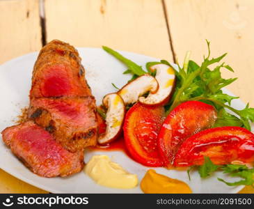 beef filet mignon grilled with fresh vegetables on side ,mushrooms tomato and arugula salad