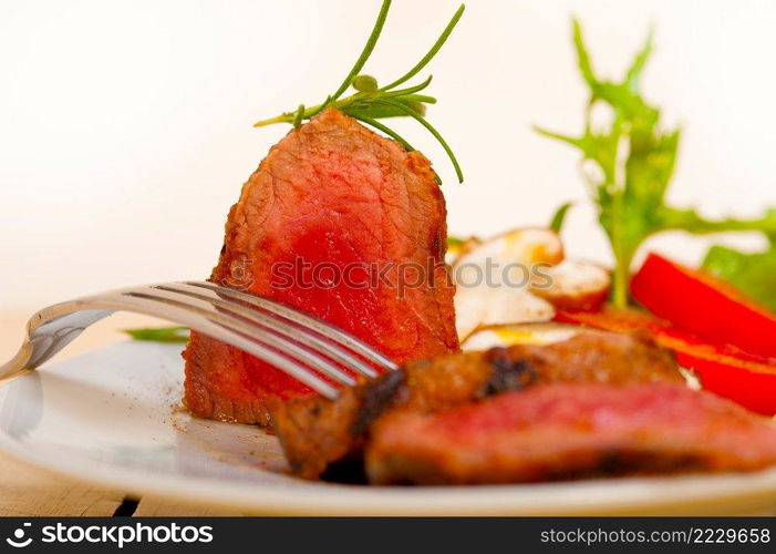 beef filet mignon grilled with fresh vegetables on side ,mushrooms tomato and arugula salad