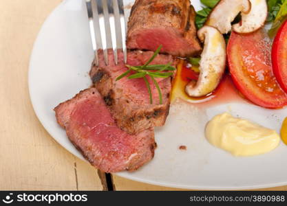 beef filet mignon grilled with fresh vegetables on side ,mushrooms tomato and arugula salad