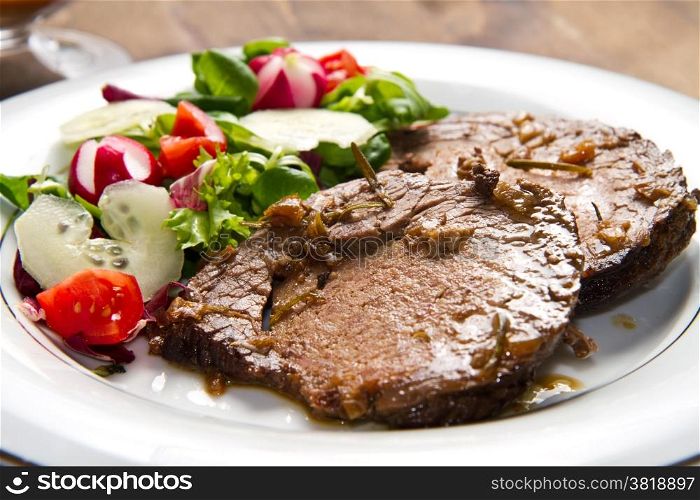 beef garnished with fresh salad, tomatoes, raddishes and cucumbers