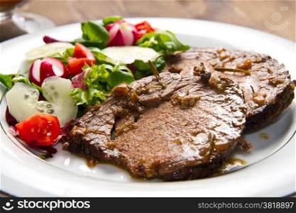 beef garnished with fresh salad, tomatoes, raddishes and cucumbers