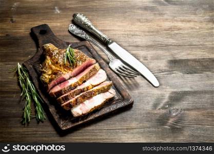 Beef grill with spices on a cutting Board. On a wooden table.. Beef grill with spices on a cutting Board.