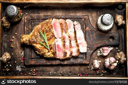 Beef grill with spices on a cutting Board. On a wooden table.. Beef grill with spices on a cutting Board.