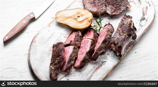 beef grilled steak. Grilled steak sliced in pear sauce on cutting board