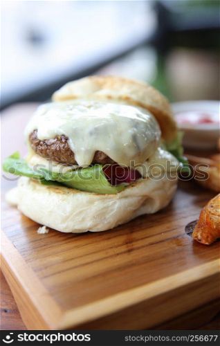 Beef hamburger with cheese and fires on wood background