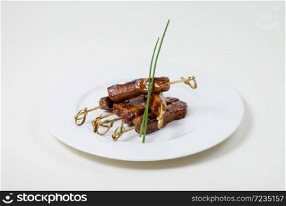 Beef Kebabs on a white plate on a white background isolated