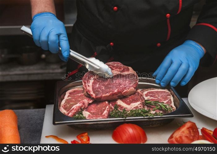 beef meat steaks. Chef hands take beef meat steaks