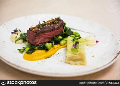 Beef meat with green peas, sweet potato mousse, roasted spinach and zucchini gratin. Beef meat with vegetables