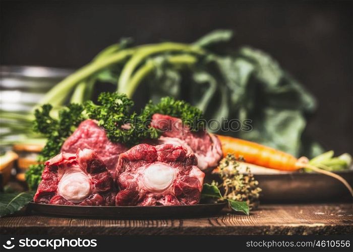 Beef Ox tail meat with bone and cooking ingredients for soup or broth on rustic kitchen table