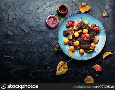 Beef ribs baked in plums and pears.Meat ribs grilled in fruit sauce on the plate.Copy space. Beef ribs baked in plums,space for text