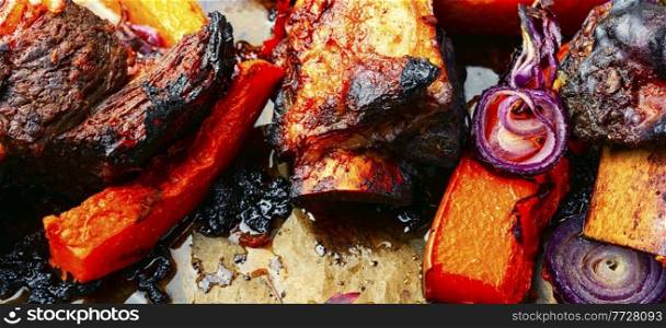 Beef ribs BBQ.Baked beef meat with slices of pumpkin.Food background. Grilled meat with autumn pumpkin