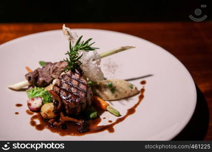 Beef sirloin steak with red wine gravy mushroom, vegetable and roasted potato in white plate - close up food shot