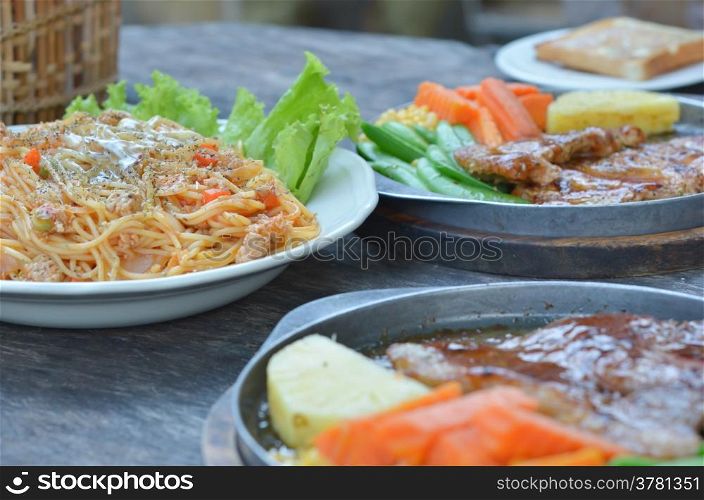 beef steak , pork steak and spaghetti , food on table