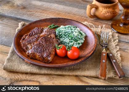 Beef steak with creamy spinach close up