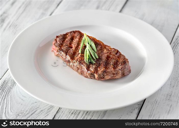 Beef steak with fresh rosemary on white plate