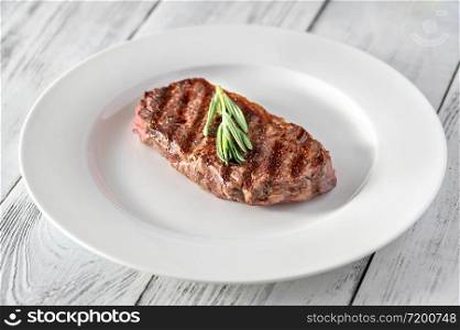 Beef steak with fresh rosemary on white plate