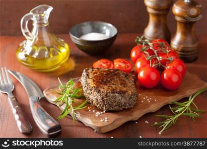 beef steak with spices and rosemary on wooden background