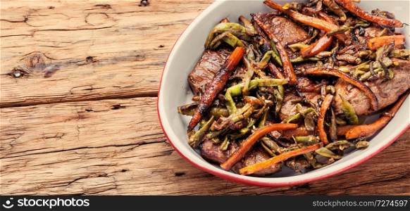 Beef steaks stewed in carrots and green beans. Beef meat stewed with vegetables