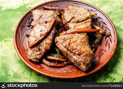 Beef steaks stewed in carrots and green beans. Beef with vegetables
