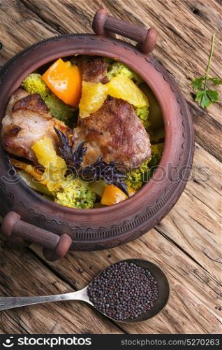 Beef stew in ceramic pot. baked meat with orange sauce in a rustic ceramic pot