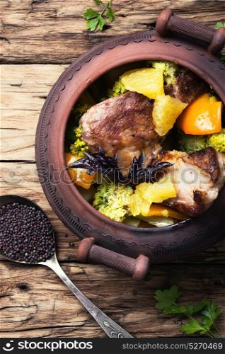 Beef stew in the pot. baked beef meat with orange sauce in a rustic pot