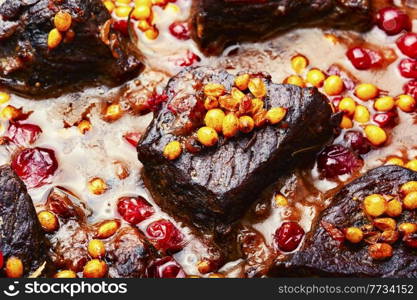Beef stewed in sea buckthorn and cranberries.Food background. Meat stewed in berries marinade