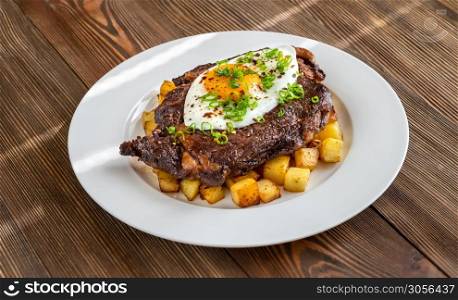 Beefsteak with fried egg and potato flat lay