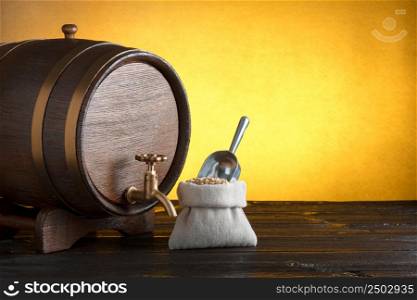 Beer barrel with a bag of beer barley with scoop on wooden table with copy-space