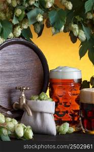 Beer barrel with beer glass, fresh hops and wheat still-life