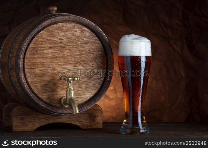 Beer barrel with beer glass on wooden table dark still-life