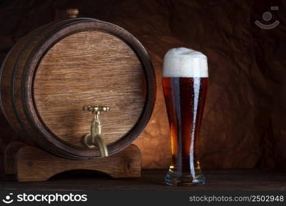 Beer barrel with beer glass on wooden table dark still-life
