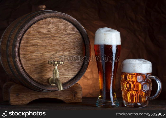 Beer barrel with two beer glasses on wooden table dark still-life