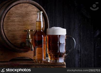 Beer bottle and glass with old wooden barrel on wooden table still life with dark background and place for text